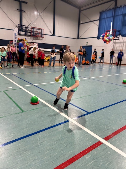 Chłopiec z grupy Srebrnej podczas konkurecji polegającej na umieszczeniu dwóch piłkek w krążku, obiegnieciu pachołka i jak najszybszego powrotu na miejsce.