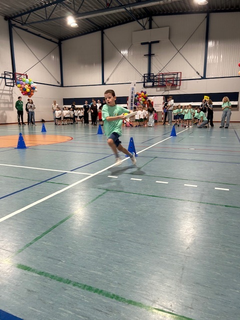 Chłopiec z grupy Turkusowej podczas konkurencji polegającej na przeniesieniu piłki tenisowej na talerzyku na czas.