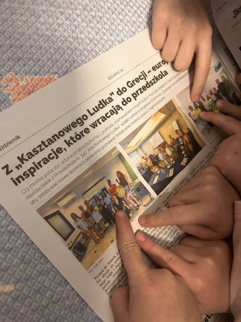 Dzieci z grupy przedszkolnej wyszukują na zdjęciach z gazety Nasze Bielany swoje wychowawczynie.