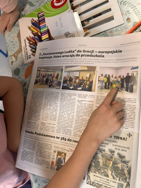 Dziecko z grupy przedszkolnej znajduje na zdjęciu z gazety Nasze Bielany symbole przedszkola P340.