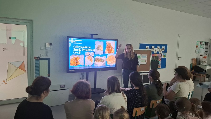 Nauczycielka przentuje kuchnię grecką, jaką osoby biorące udział w projekcie Erasmus miały okazję poznać w Grecji.